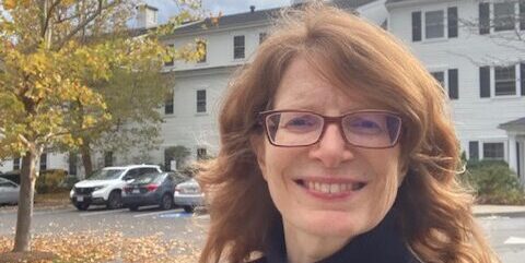 Caroline in black turtleneck in an autumn residential area